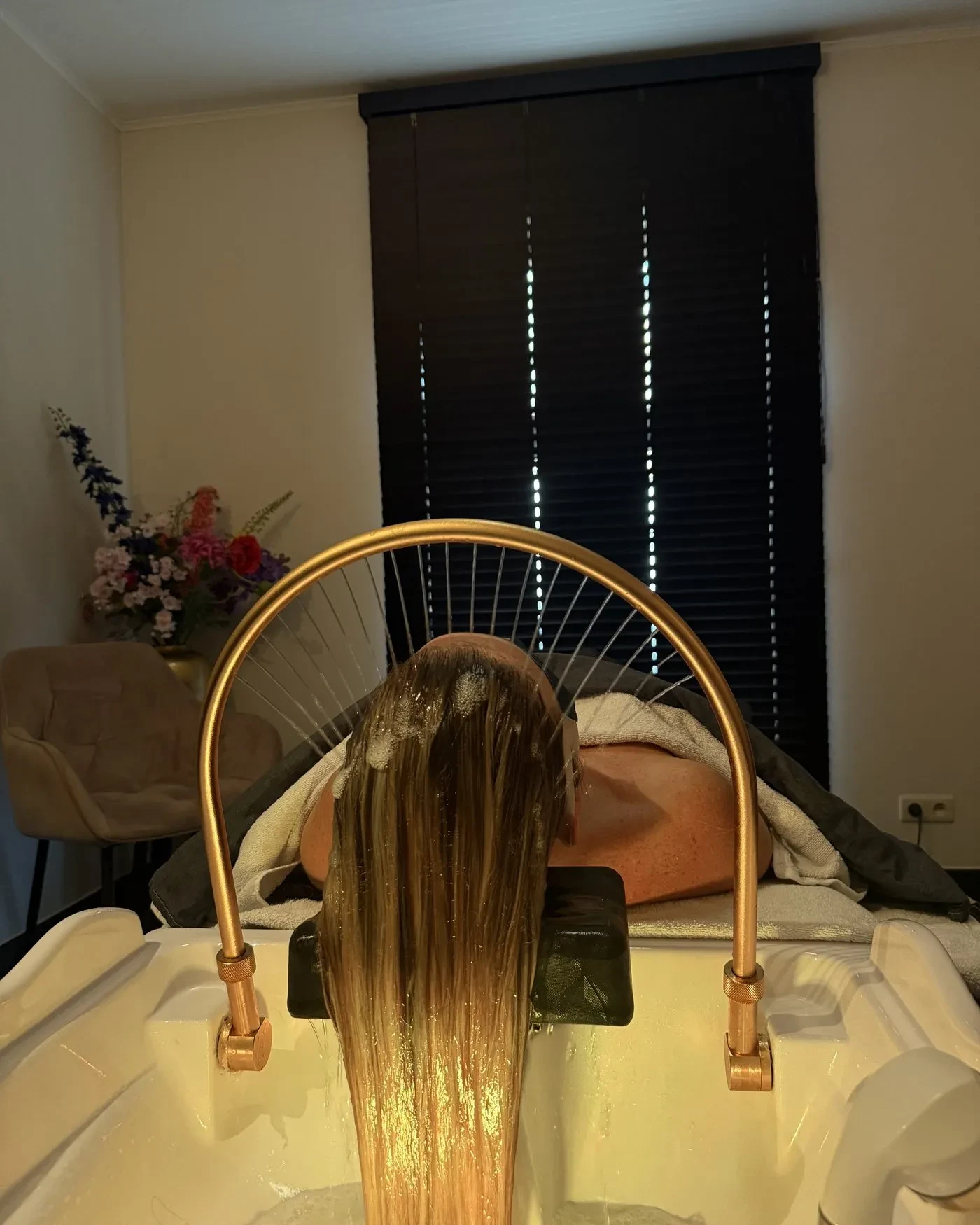 Head spa ritual: a curtain of warm water from the arch over the basin, client at rest